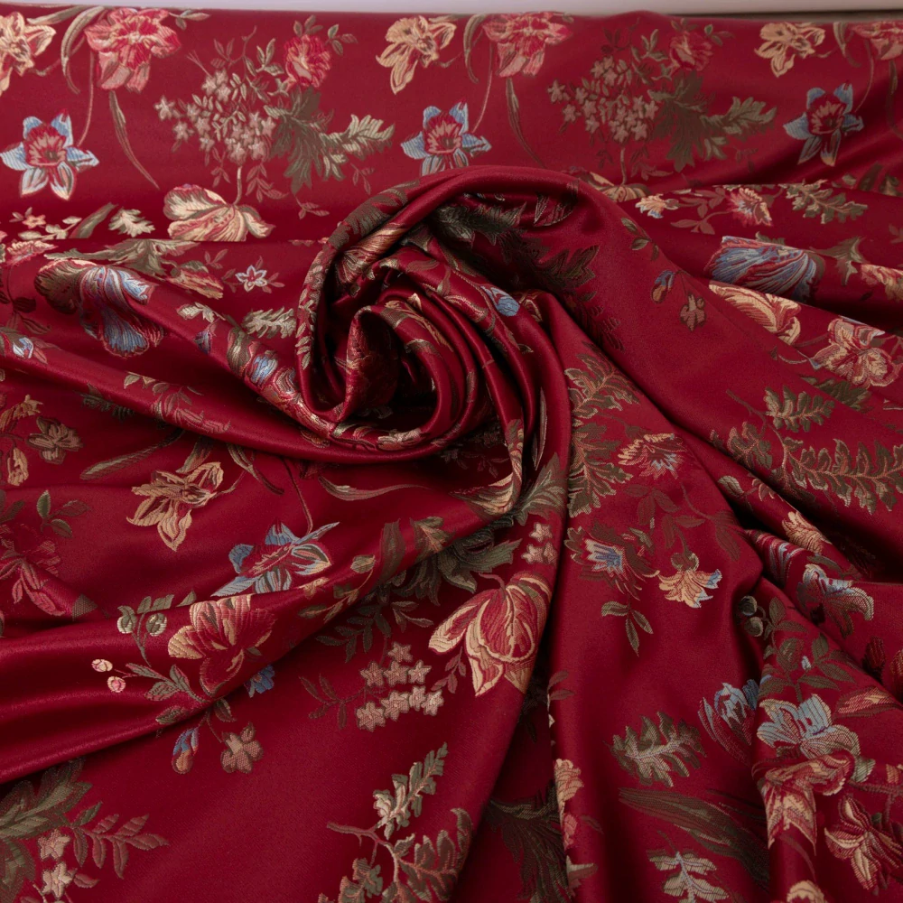 Tkané květy na rubínově červeném podkladu