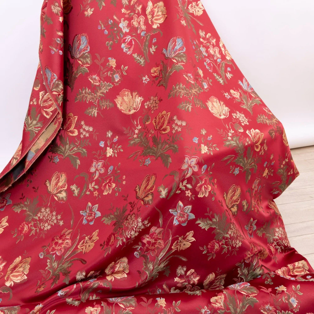 Tkané květy na rubínově červeném podkladu