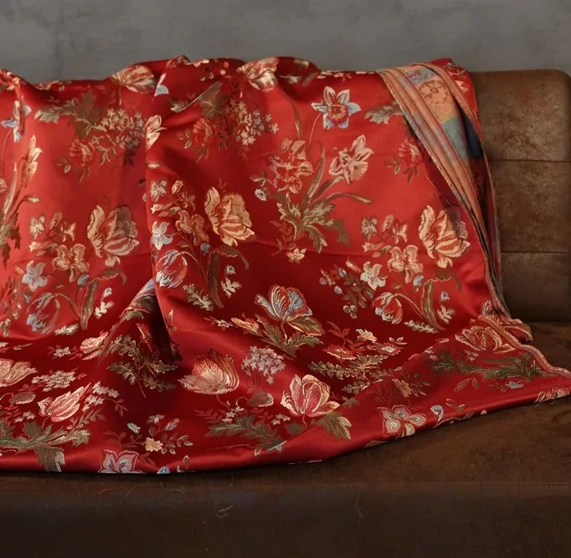 Tkané květy na rubínově červeném podkladu